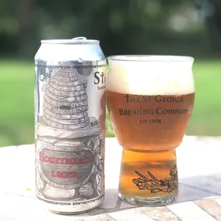 a glass of beer next to a can