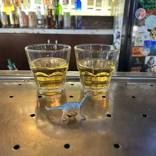 two glasses of beer on a bar