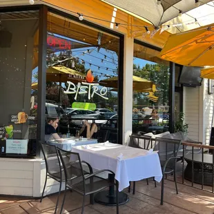a woman sitting at a table outside a restaurant