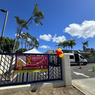 a gate with a sign and balloons