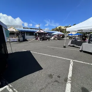 a parking lot with tables and umbrellas