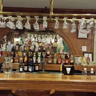 a bar with wine glasses hanging from the ceiling