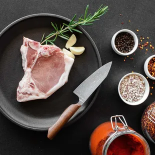a steak on a plate with a knife and spices