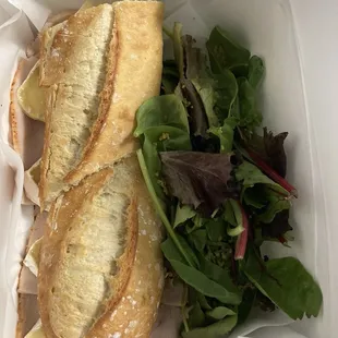 Fresh homemade baguette with Brie and turkey-and salad with homemade mustard vinaigrette