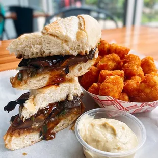 Flavor Bomb Pho Dip Sandwich with side of Crispy Tater Tots.