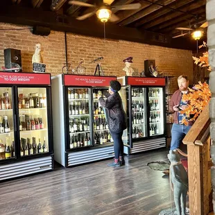 two people standing in front of refrigerators