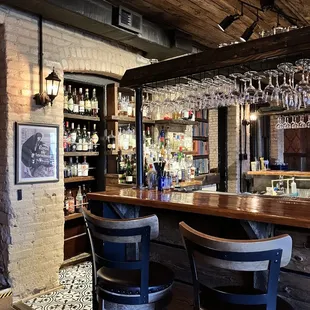 a bar with wine glasses hanging from the ceiling