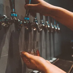 a person filling a glass of water