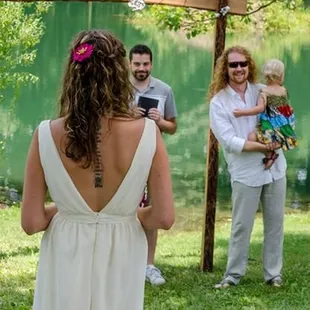 a woman in a white dress standing in front of a group of people