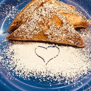 a heart drawn in powdered sugar on a blue plate