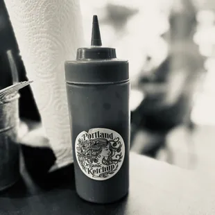 a black and white photo of a bottle of ketchup