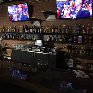 a bar with two televisions on the wall