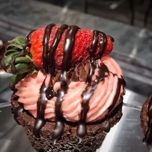 a strawberry and chocolate covered cupcake