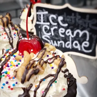 a close up of a chocolate sundae with sprinkles and a cherry