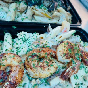 two trays of pasta and shrimp