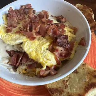 Breakfast bowl (3/5) potatoes, gray, cheese, eggs, bacon &amp; sausage w/ biscuit on the side.