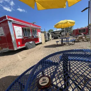 a red food truck and yellow umbrellas