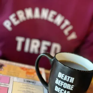 a person sitting at a table with a cup of coffee