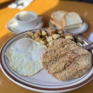 Country fried steaks with country potatoes, over easy, eggs, and sourdough toast
