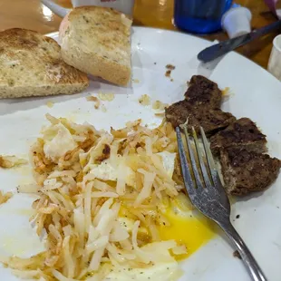 Half eaten eggs, turkey sausage, hash browns with rye toast