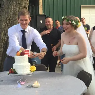 a bride and groom cutting their wedding cake