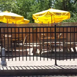 tables and umbrellas behind a fence