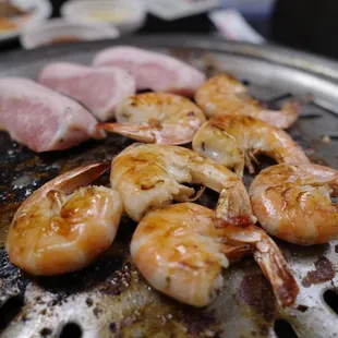 a close up of shrimp and meat on a grill