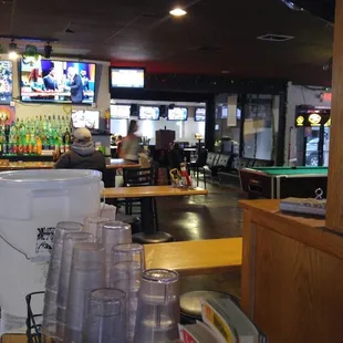 a view of a sports bar with tables and televisions