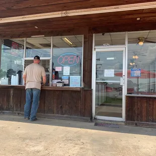 a man standing in front of a restaurant