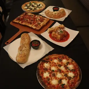 a table with pizzas and bread