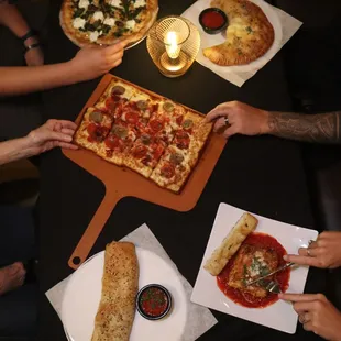 a group of people eating pizza