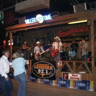 a group of people dancing in front of a bar