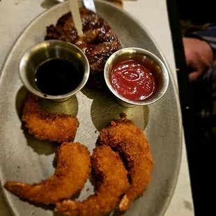 a platter of food with dipping sauces