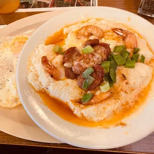 Cheesy shrimp grits with andouille sausage and side of fried eggs.