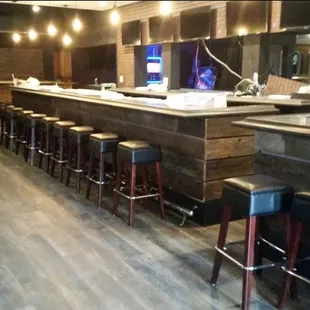 a bar with stools and a television