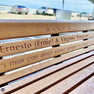 a wooden bench with engraved names