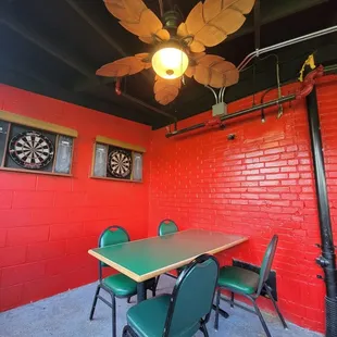 a red brick wall and green chairs