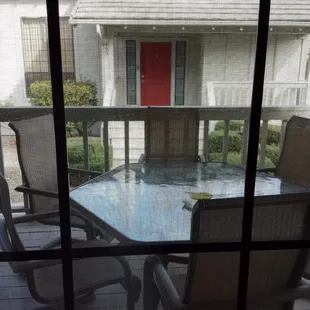 Outdoor patio with table and view of a cottage behind.