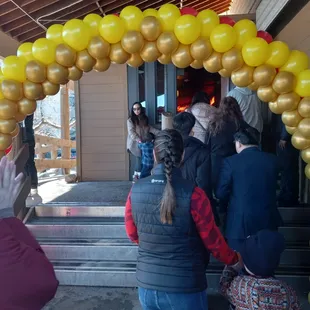 a group of people standing under a balloon arch