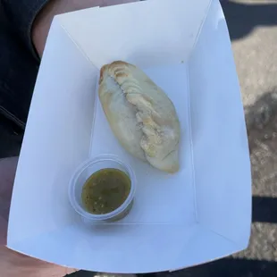 a person holding a sandwich in a paper box