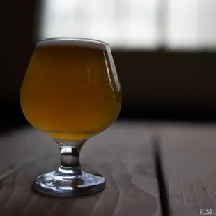 a glass of beer on a wooden table