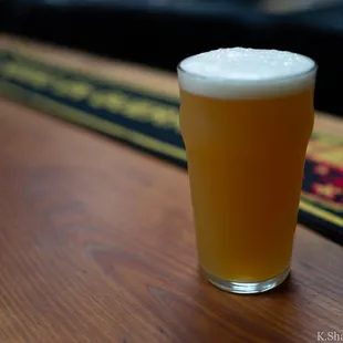 a glass of beer on a bar