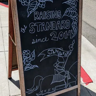 a chalkboard sign on a sidewalk