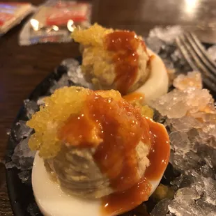 two deviled eggs on a bed of ice
