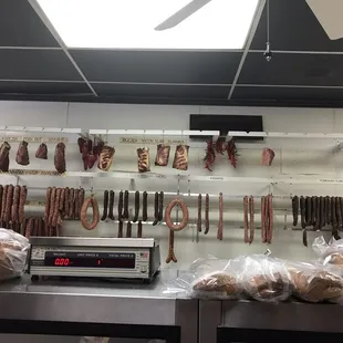 a variety of sausages hanging on the wall