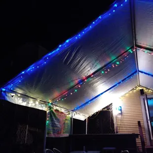 a covered patio with christmas lights