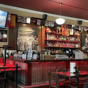 ows a bar with red booths and tables