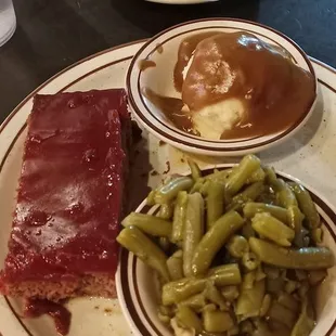 Meatloaf with mashed potatoes and gravy, green beans, and cornbread.