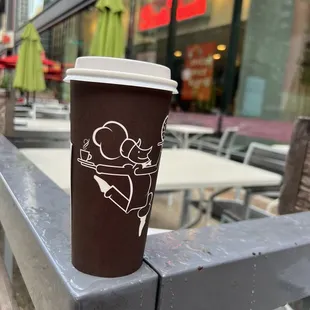 a cup of coffee on a bench