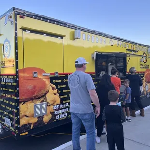 a group of people standing in front of a food truck